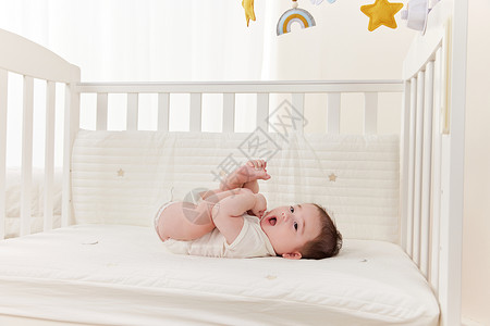 看星星的孩子躺在婴儿床上看床铃的可爱宝宝背景