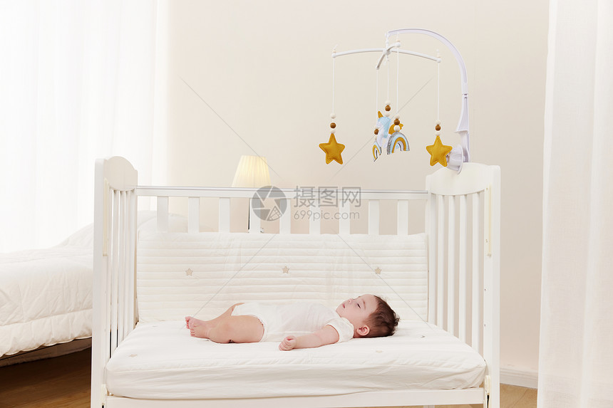 躺在婴儿床上看床铃的宝宝图片
