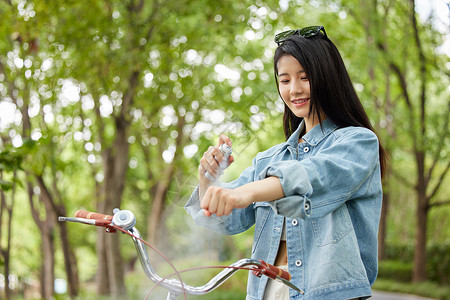 在室外骑行的美女使用补水喷雾图片