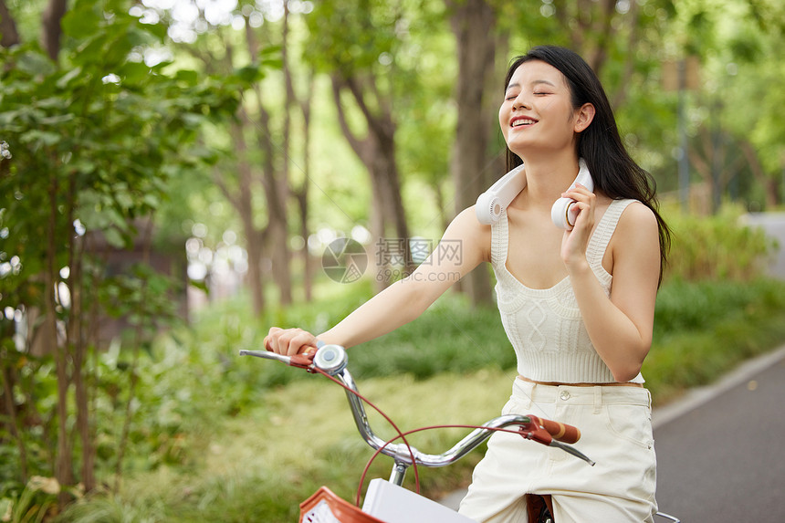 戴着挂脖风扇的骑行美女图片