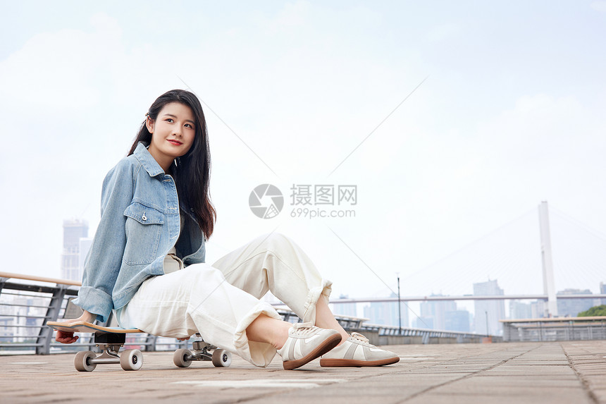 坐在滑板上的时尚美女图片