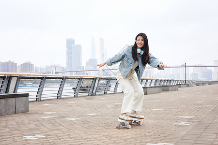 街头时尚美女玩滑板背景图片