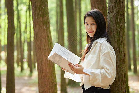 初秋女装促销在树林里看书休闲的美女背景