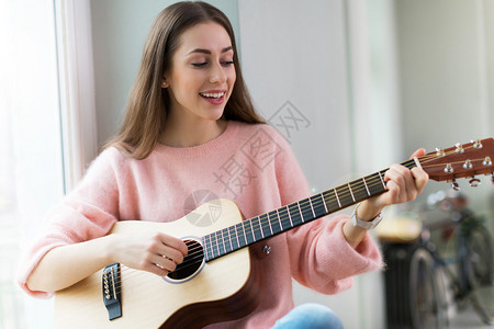 在家弹吉他的年轻女人图片