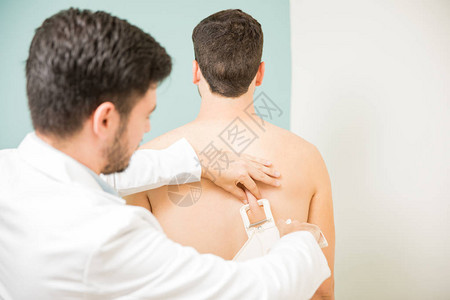 医生测量身体脂肪的后视镜和病人背部图片