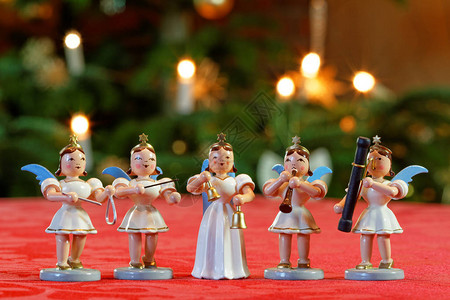 五位装饰天使在圣诞树灯前演奏音图片