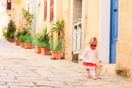 可爱的小女孩小心的在街道旁慢慢走路图片