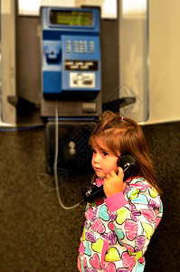 小女孩在公用电话上讲话图片