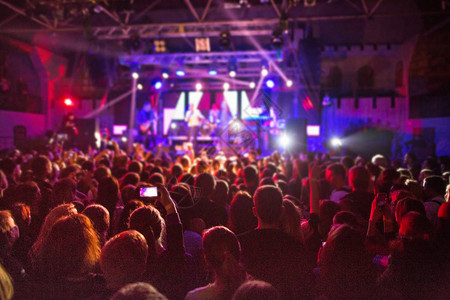 音乐会群众在明亮的舞台灯前的轮廓图片