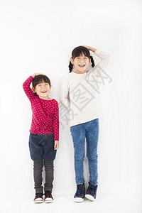 快乐的孩子站在白墙前图片