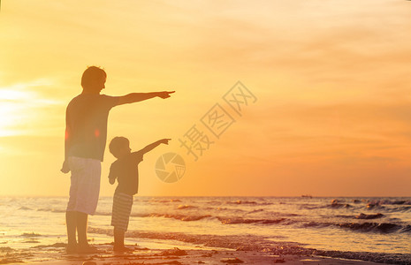 父亲和儿子在日落海背景图片