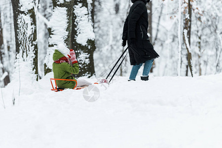 女儿和妈在雪地里骑着雪橇图片