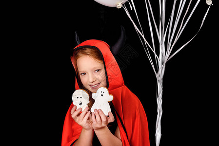 小孩穿着圣灵装扮的恶魔带着幽灵饼干在图片