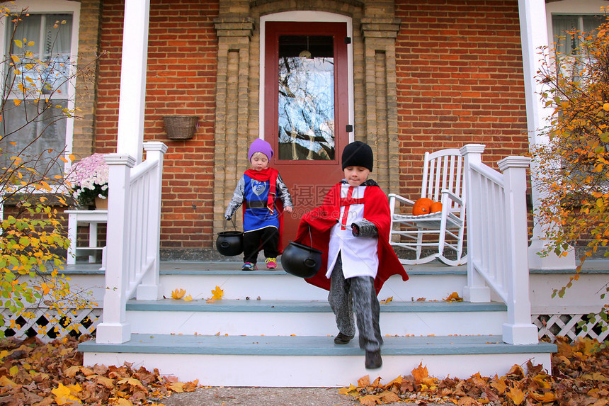 两个身着骑士服装的年轻美国儿童在万圣节上讨要糖果图片