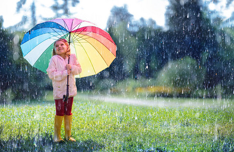 雨下带彩虹伞的快乐孩子图片