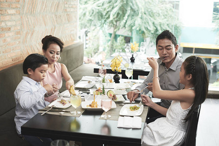 亚裔家庭在餐厅吃午饭背景图片