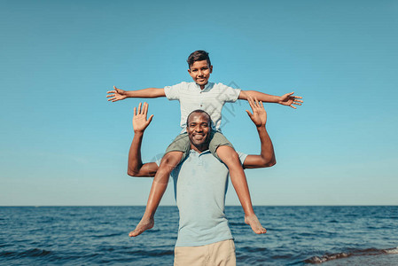 快乐的非洲美国快乐的父亲带着可爱笑的儿子图片
