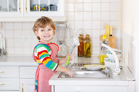 可爱快乐的金发小男孩在国内厨房洗碗孩子很开心帮助他的父母做家务在室内图片