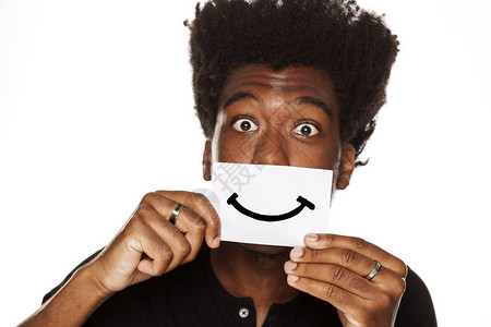 带着微笑的快乐的非洲青年男子在一张白色背景的纸图片