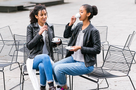 两个北非青少年朋友在外边一起喝咖啡图片