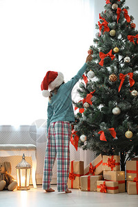 在家里装饰圣诞树的圣诞帽子图片