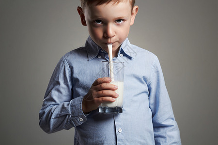 有趣的孩子喝牛奶小英俊的男孩享受牛奶鸡尾图片