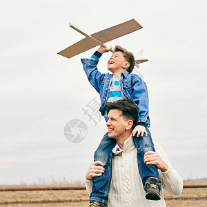 照片快乐的男孩与玩具飞机和父亲一图片
