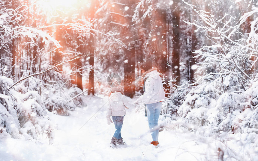 年轻家庭散步妈和女儿在雪地公图片