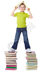 一个快乐的男孩站在两堆书上拿着一本背景图片