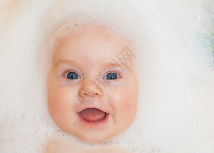 婴儿在有泡沫的浴缸里洗澡图片