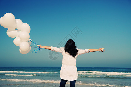 在海边装着白气球背景图片