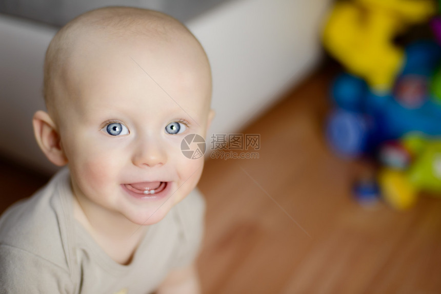 6个月婴儿在家中玩乐时展示他头两颗图片