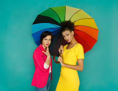 担心身着彩虹色伞下闲谈的花彩散衣女孩图片