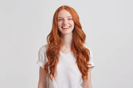 长的卷发和雀斑穿着时装T衬衫的漂亮可爱红发年轻女人的肖像图片