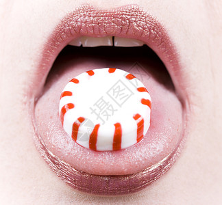 女人舌头上薄荷糖的特写背景图片