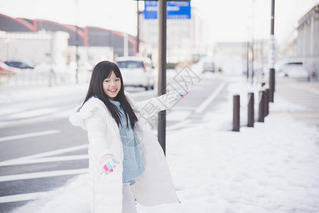 路边享受下雪的女孩图片