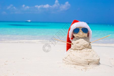 用沙子堆成的雪人带了一顶圣诞帽图片
