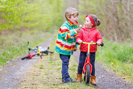 女孩和男孩子在雨天骑着自行车图片
