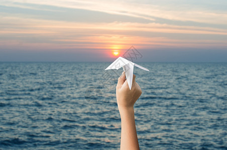 儿童手持飞机纸和日落向图片