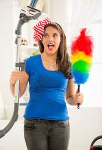 一个微笑的年轻美女打扫房子的肖像图片