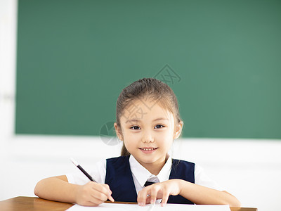 快乐的小女孩在教室里写作业图片