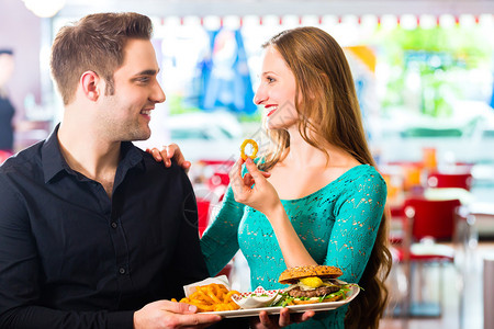 朋友或夫妇在美国快餐厅吃快餐汉堡图片
