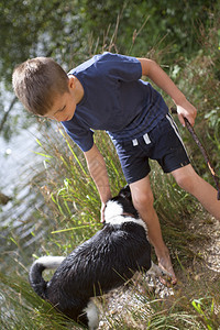 小男孩和狗在湖图片