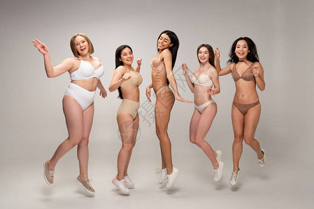 穿着内衣的5个漂亮的多文化女孩玩得开心跳高清图片