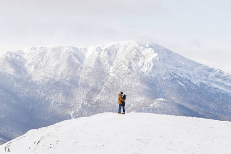 喜爱在山上亲吻的情侣在雪图片