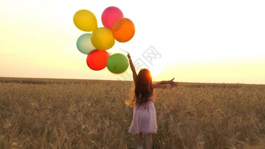 女孩带着气球在田野里散步图片
