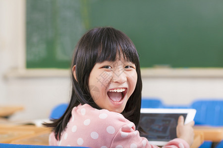 快乐的小女学生在书桌上拿着图片