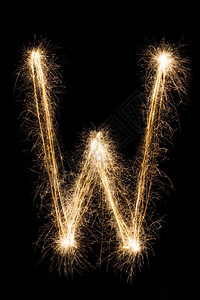 英文大字母W由黑色背景上的燃烧火花制成闪亮的节日派对烟花字体背景图片