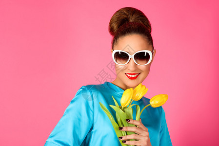 穿着蓝丝裙和白太阳镜的年轻美女肖像黄色的郁金香露图片