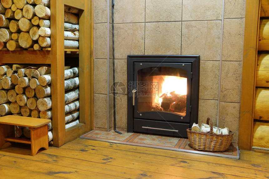 一个烧木头的炉子和一篮桦木柴火在农村的木屋里图片